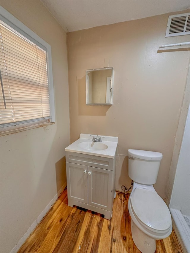 bathroom featuring vanity, hardwood / wood-style floors, and toilet