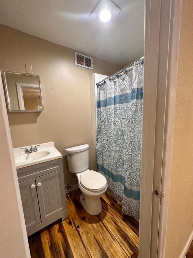 bathroom featuring wood-type flooring, a shower with shower curtain, vanity, and toilet