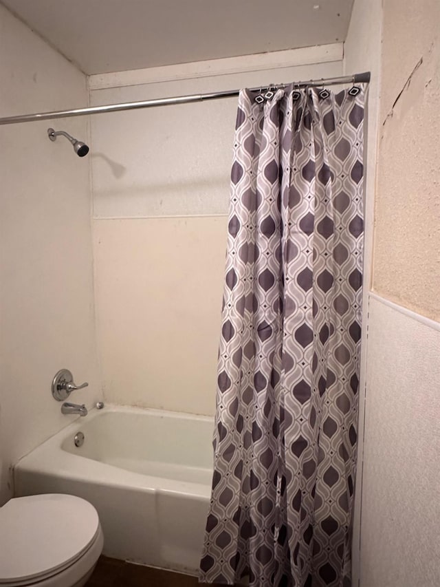 bathroom featuring shower / bathtub combination with curtain and toilet