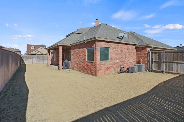 721 N 7th St, Wolfforth, TX 79382 - back of house with a chimney, a fenced backyard, a shingled roof, a patio area, and brick siding