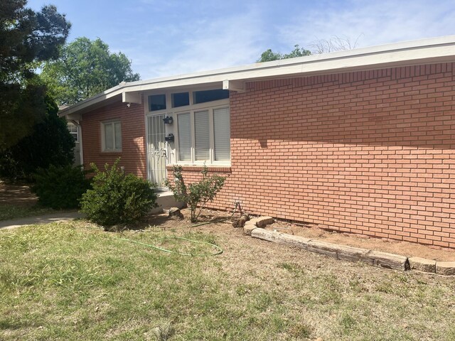 2602 45th St, Lubbock, TX 79413 - view of front of house featuring brick siding and a front yard