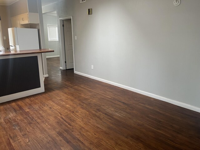 2602 45th St, Lubbock, TX 79413 - kitchen with freestanding refrigerator, dark wood-style floors, white cabinets, baseboards, and butcher block countertops
