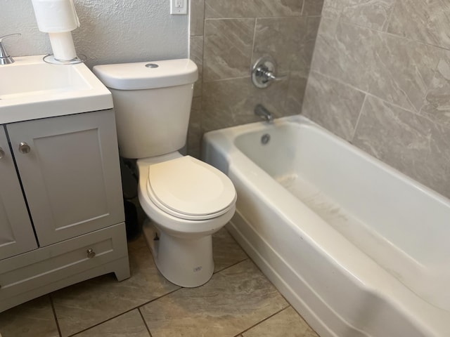 2602 45th St, Lubbock, TX 79413 - bathroom featuring toilet, vanity, a textured wall, bathtub / shower combination, and tile patterned floors