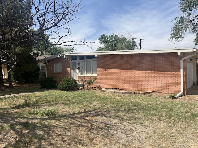 2602 45th St, Lubbock, TX 79413 - view of side of home with brick siding and a yard