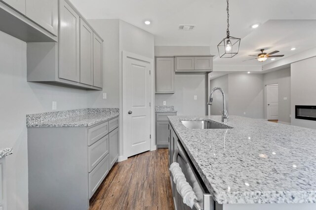 kitchen featuring pendant lighting, sink, gray cabinets, dishwasher, and dark hardwood / wood-style floors