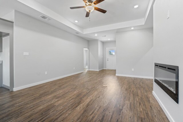 unfurnished living room featuring dark hardwood / wood-style floors and ceiling fan