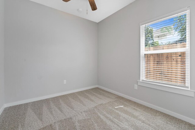 carpeted spare room with ceiling fan