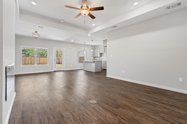 unfurnished living room with dark wood-type flooring and ceiling fan