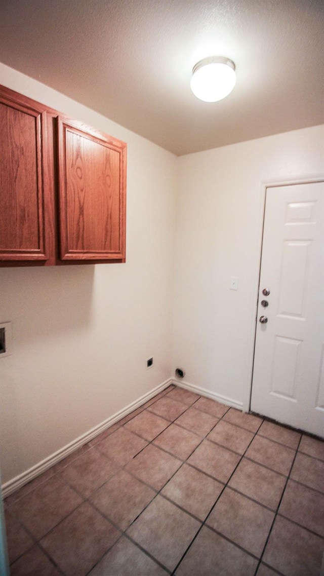 washroom featuring cabinets, hookup for a washing machine, and light tile patterned floors