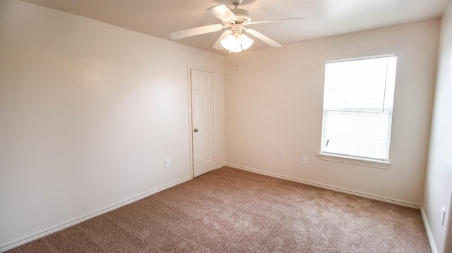 carpeted spare room featuring ceiling fan