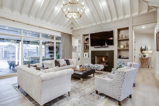 4821 119th Pl, Lubbock, TX 79424 - living room with a chandelier, built in features, light wood-style floors, a warm lit fireplace, and lofted ceiling
