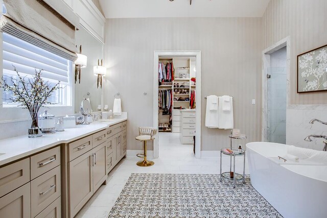 4821 119th Pl, Lubbock, TX 79424 - full bathroom featuring a shower with shower door, a freestanding bath, double vanity, a walk in closet, and tile patterned floors