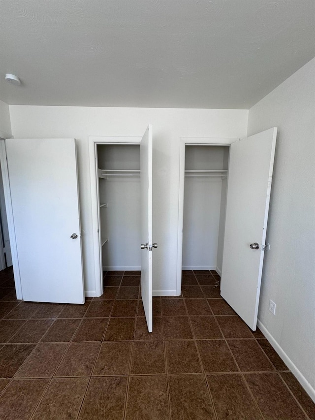 unfurnished bedroom featuring two closets