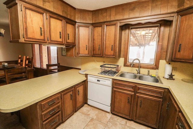 kitchen featuring dishwasher, sink, kitchen peninsula, and a wealth of natural light