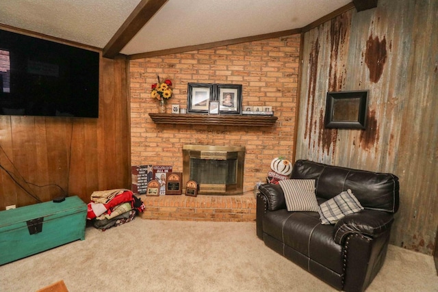 carpeted living room with a textured ceiling, lofted ceiling with beams, a brick fireplace, and wood walls