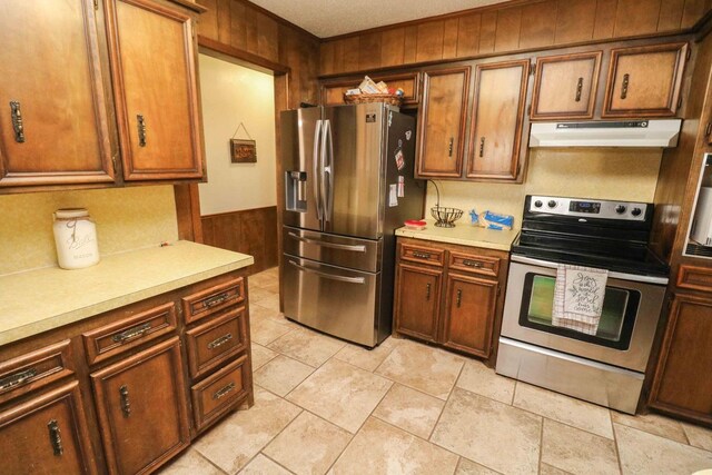 kitchen with appliances with stainless steel finishes and wood walls