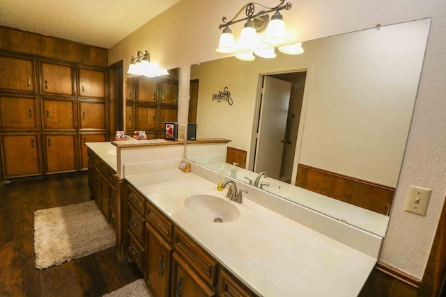 bathroom featuring hardwood / wood-style flooring, vanity, and an inviting chandelier