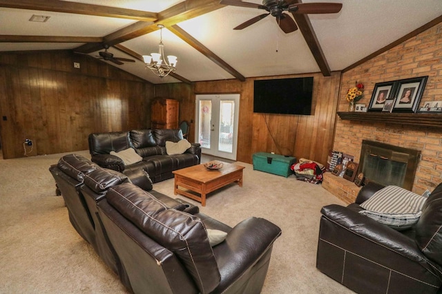 carpeted living room with lofted ceiling with beams, a brick fireplace, wooden walls, and french doors