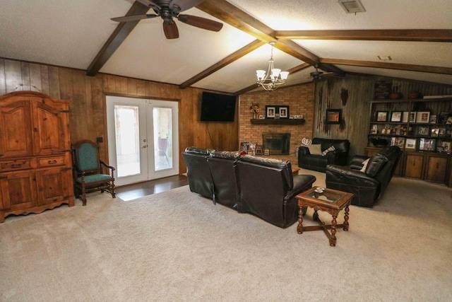 carpeted living room featuring a brick fireplace, vaulted ceiling with beams, wood walls, and french doors