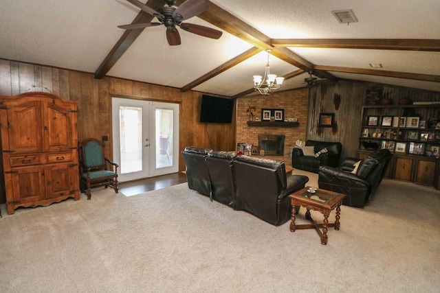 carpeted living room featuring french doors, wood walls, a fireplace, and vaulted ceiling with beams