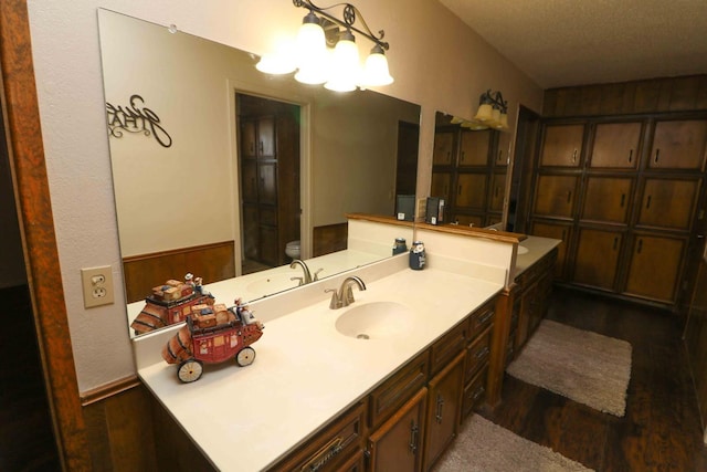 bathroom featuring vanity, toilet, a chandelier, and hardwood / wood-style floors