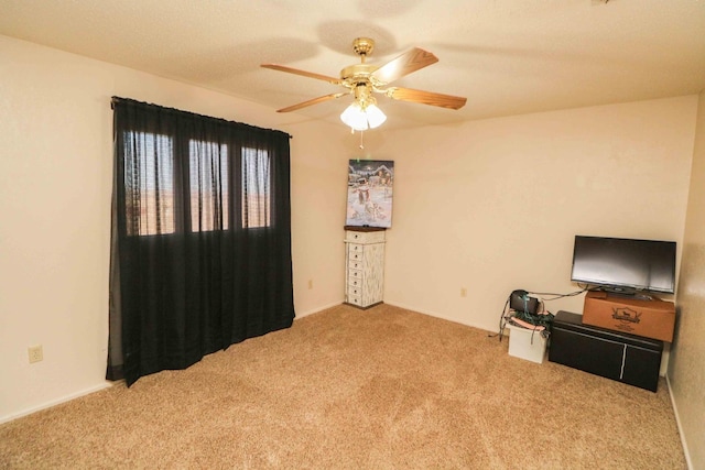 interior space with light carpet and ceiling fan