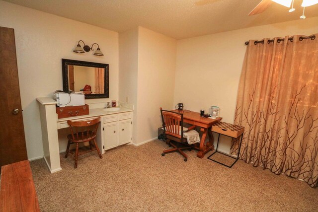 office area featuring ceiling fan, sink, light carpet, and a textured ceiling