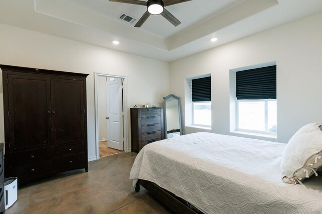 bedroom featuring a raised ceiling and ceiling fan