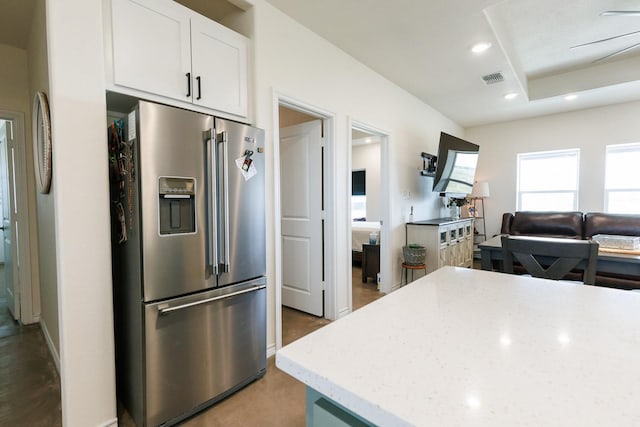 kitchen with light stone counters, high end refrigerator, and white cabinets