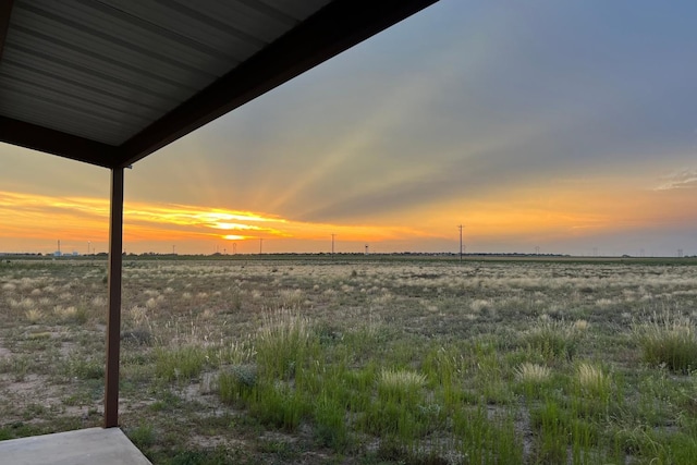 yard at dusk featuring a rural view