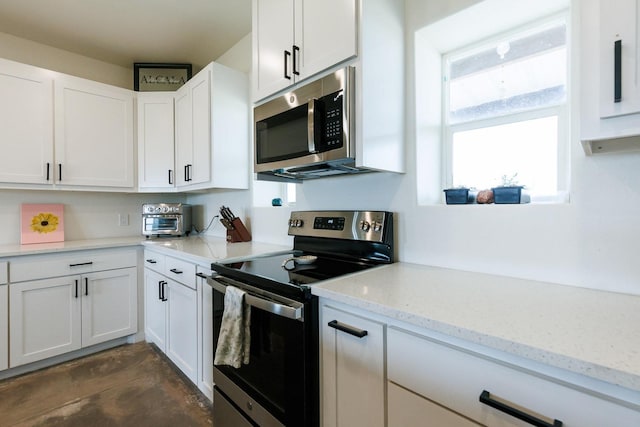 kitchen with light stone counters, stainless steel appliances, and white cabinets