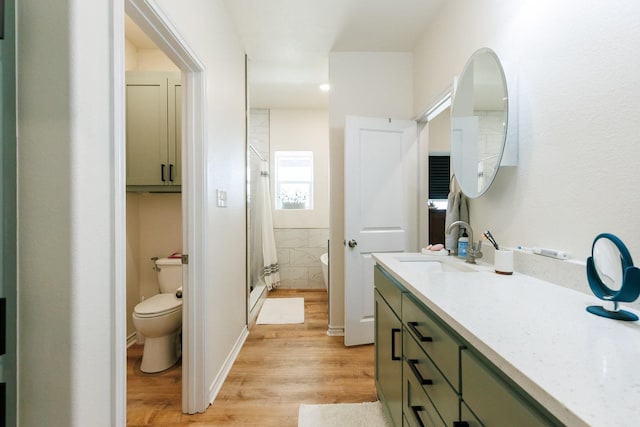 bathroom with wood-type flooring, toilet, a shower with door, and vanity