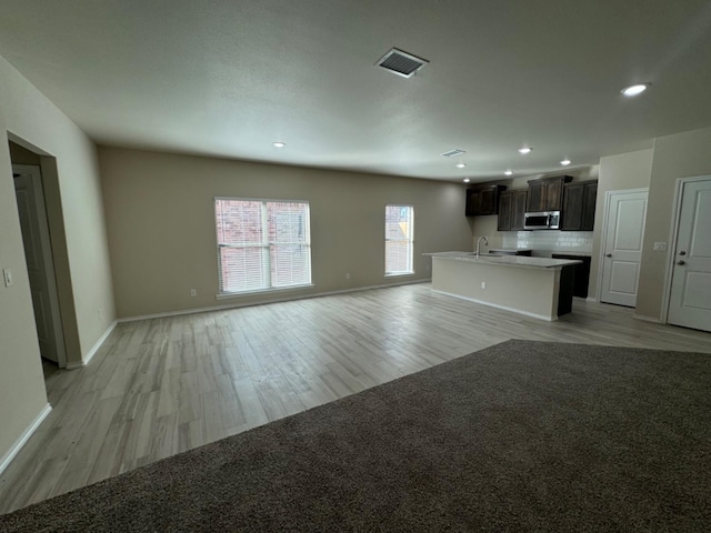 unfurnished living room featuring sink and light wood-type flooring