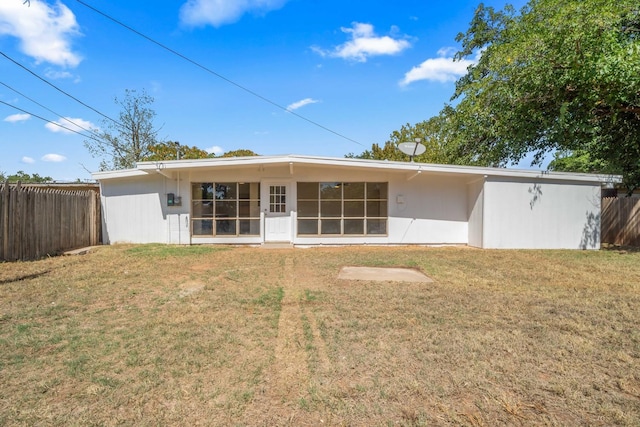 back of house featuring a sunroom and a yard