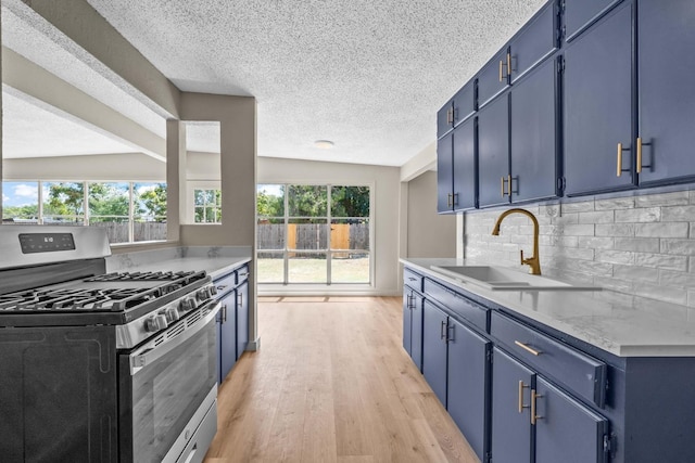 kitchen with blue cabinets, sink, and stainless steel gas stove