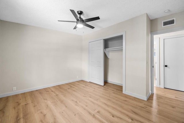 unfurnished bedroom with ceiling fan, a closet, a textured ceiling, and light wood-type flooring