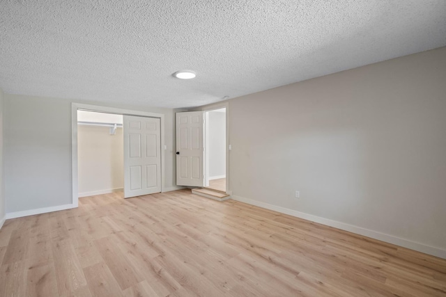 spare room with light hardwood / wood-style flooring and a textured ceiling