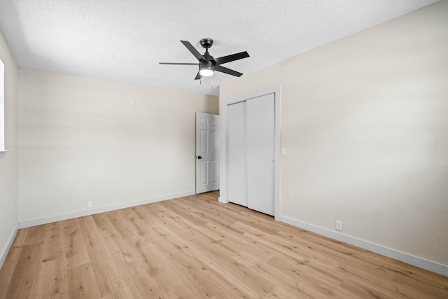 unfurnished bedroom featuring ceiling fan, a textured ceiling, light hardwood / wood-style floors, and a closet