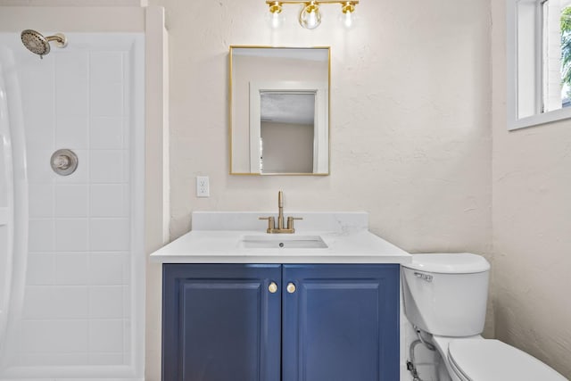 bathroom with vanity, toilet, and a tile shower