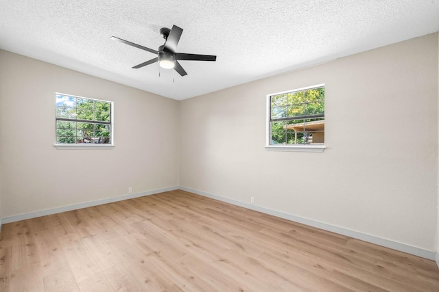 unfurnished room with ceiling fan, a textured ceiling, a healthy amount of sunlight, and light wood-type flooring