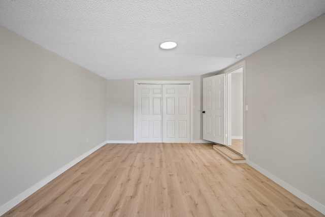 unfurnished bedroom featuring a closet, a textured ceiling, and light hardwood / wood-style flooring