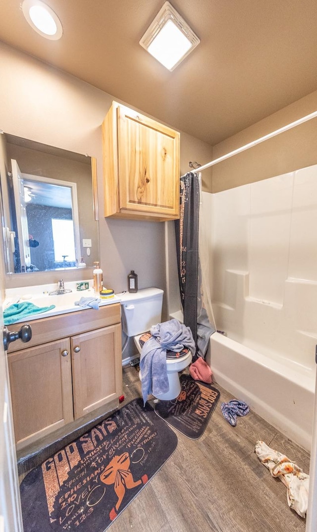 full bathroom with shower / tub combo, vanity, hardwood / wood-style flooring, and toilet