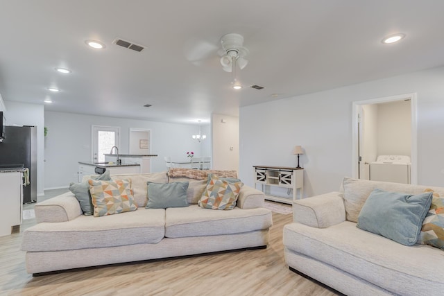 8413 10th Pl, Lubbock, TX 79416 - living room featuring washer / dryer, a ceiling fan, light wood finished floors, recessed lighting, and a chandelier