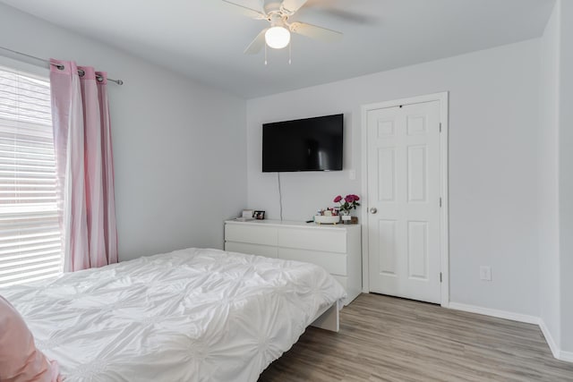8413 10th Pl, Lubbock, TX 79416 - bedroom with multiple windows, light wood-style flooring, baseboards, and a ceiling fan