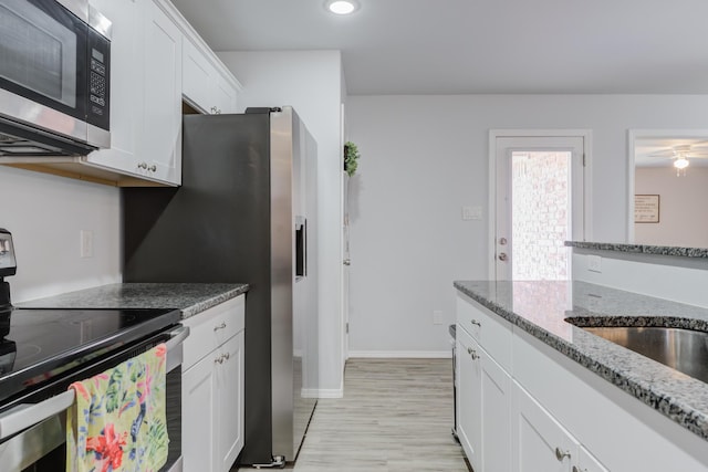 8413 10th Pl, Lubbock, TX 79416 - kitchen featuring stainless steel appliances, white cabinets, light wood-style floors, stone countertops, and recessed lighting