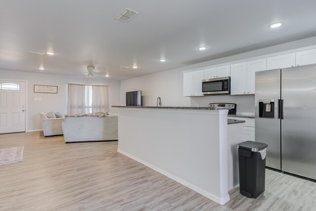 8413 10th Pl, Lubbock, TX 79416 - kitchen with stainless steel appliances, light wood-type flooring, white cabinets, baseboards, and recessed lighting