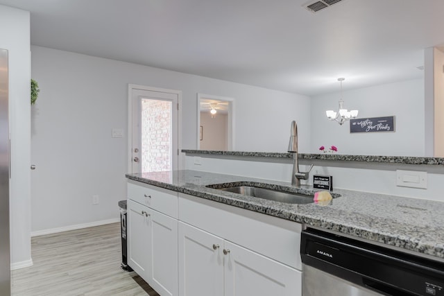 8413 10th Pl, Lubbock, TX 79416 - kitchen with dishwasher, a sink, white cabinets, light stone counters, and light wood-style flooring