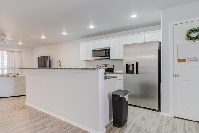 8413 10th Pl, Lubbock, TX 79416 - kitchen featuring appliances with stainless steel finishes, light wood finished floors, a kitchen island, white cabinets, and a sink
