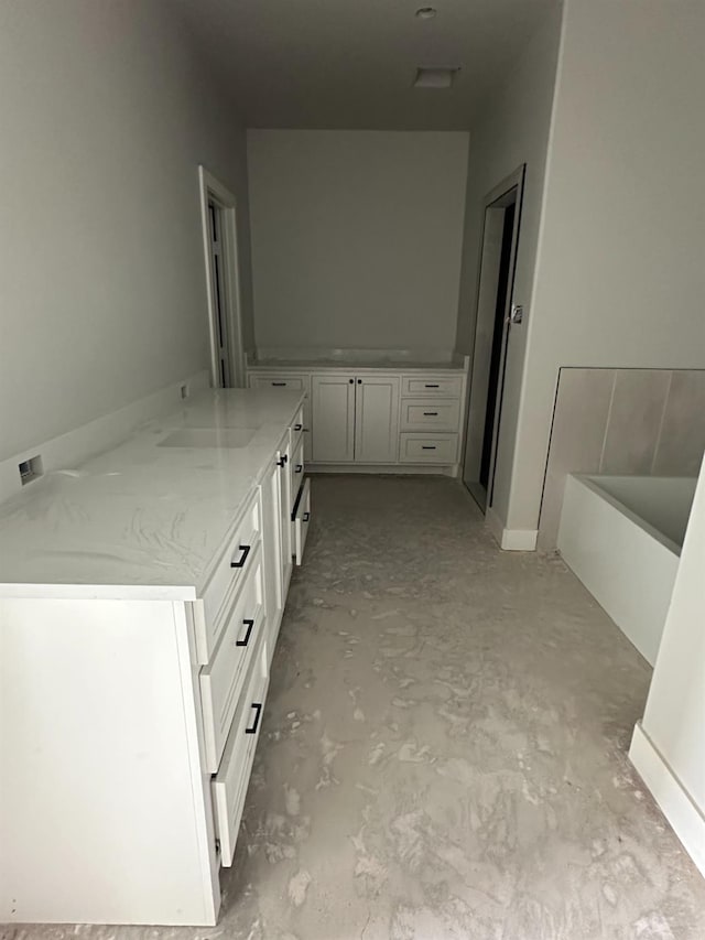 bathroom featuring vanity, concrete floors, and a bathing tub