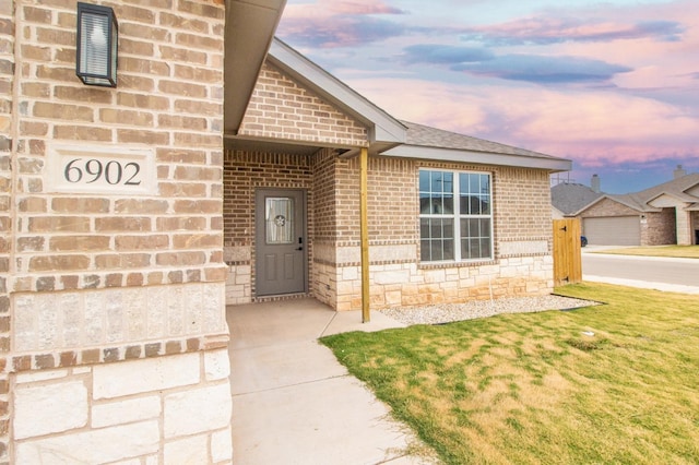 exterior entry at dusk with a lawn